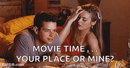 A Man And A Woman Are Laying On A Bed And The Woman Is Putting Her Hand On The Man 'S Forehead . GIF