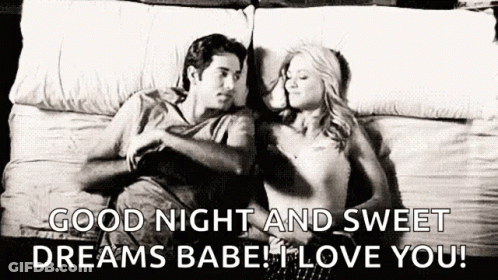 A Man And A Woman Are Laying On A Bed Together . GIF