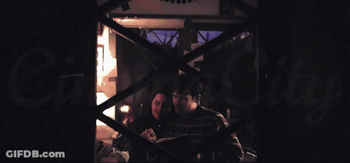 A Man And A Woman Are Laying On A Bed With A Canopy GIF