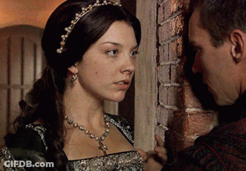 A Man And A Woman Are Leaning Against A Brick Wall Looking At Each Other GIF