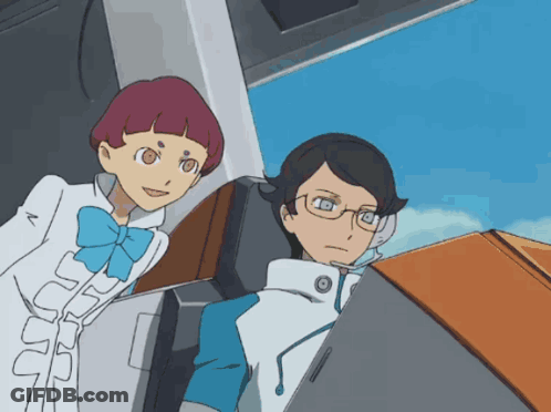 A Man And A Woman Are Looking At A Computer Screen GIF