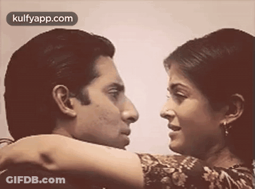 A Man And A Woman Are Looking At Each Other . GIF