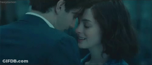 A Man And A Woman Are Looking At Each Other And Kissing . GIF