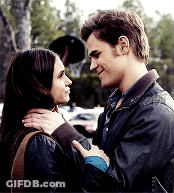 A Man And A Woman Are Looking At Each Other And Smiling GIF