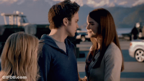 A Man And A Woman Are Looking At Each Other And Smiling GIF