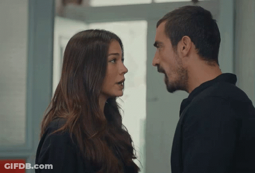 A Man And A Woman Are Looking At Each Other And Talking GIF