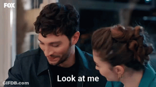 A Man And A Woman Are Looking At Each Other And The Man Is Saying Look At Me GIF