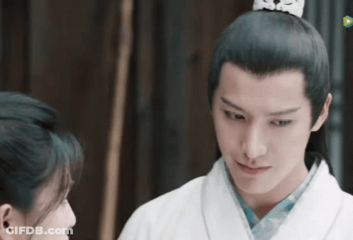 A Man And A Woman Are Looking At Each Other And The Man Is Wearing A Crown On His Head . GIF