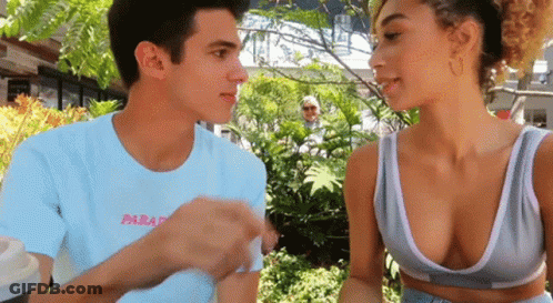 A Man And A Woman Are Looking At Each Other And The Man Is Wearing A Shirt That Says Paradis GIF
