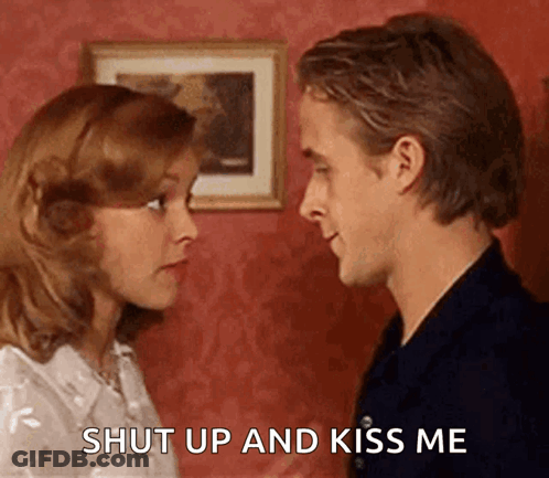 A Man And A Woman Are Looking At Each Other And The Man Says Shut Up And Kiss Me . GIF