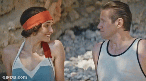 A Man And A Woman Are Looking At Each Other And The Woman Has A Red Headband On GIF