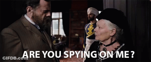 A Man And A Woman Are Looking At Each Other And The Woman Is Asking The Man If He Is Spying On Her . GIF