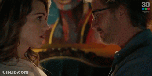 A Man And A Woman Are Looking At Each Other And The Woman Is Saying Contestame GIF