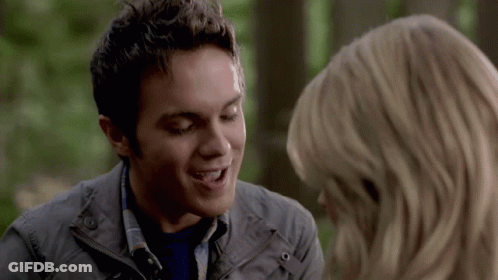 A Man And A Woman Are Looking At Each Other And The Woman Is Smiling GIF