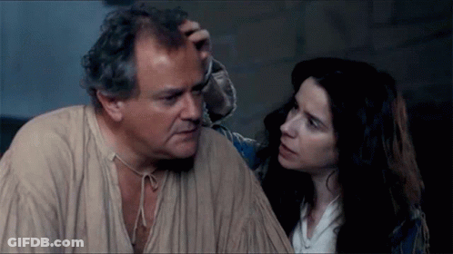 A Man And A Woman Are Looking At Each Other And The Woman Is Touching The Man 'S Forehead GIF