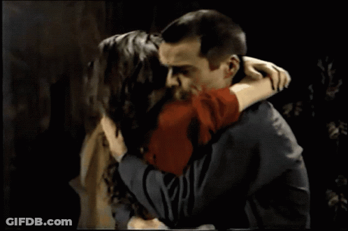 A Man And A Woman Are Looking At Each Other And The Woman Is Wearing A Ring On Her Finger GIF