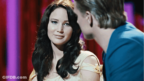 A Man And A Woman Are Looking At Each Other And The Woman Is Wearing A White Dress GIF