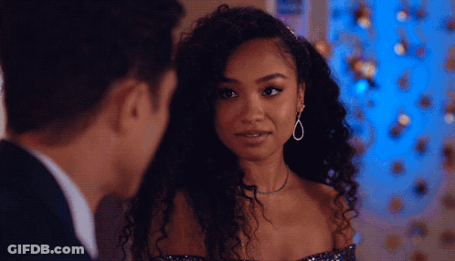 A Man And A Woman Are Looking At Each Other And The Woman Is Wearing Earrings GIF