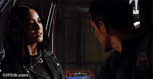 A Man And A Woman Are Looking At Each Other In A Car . The Woman Is Wearing A Leather Jacket . GIF