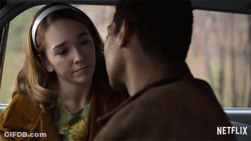 A Man And A Woman Are Looking At Each Other In A Car With Netflix Written On The Bottom GIF