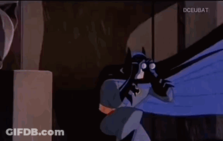 A Man And A Woman Are Looking At Each Other In A Dark Room . GIF