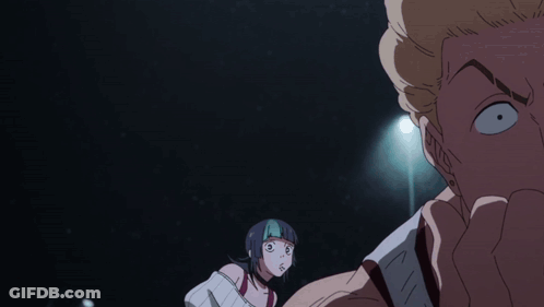 A Man And A Woman Are Looking At Each Other In A Dark Room With A Light Behind Them GIF