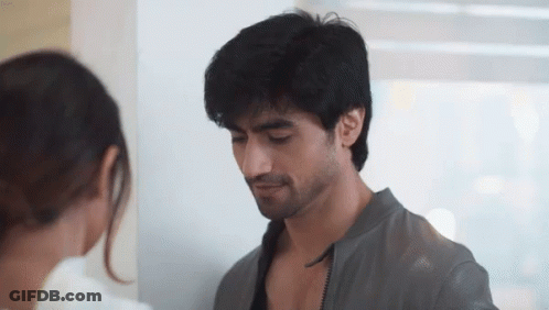 A Man And A Woman Are Looking At Each Other In A Room GIF