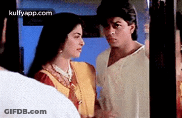 A Man And A Woman Are Looking At Each Other In A Room . GIF