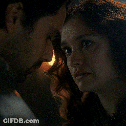 A Man And A Woman Are Looking At Each Other In The Dark GIF