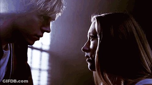 A Man And A Woman Are Looking At Each Other . GIF