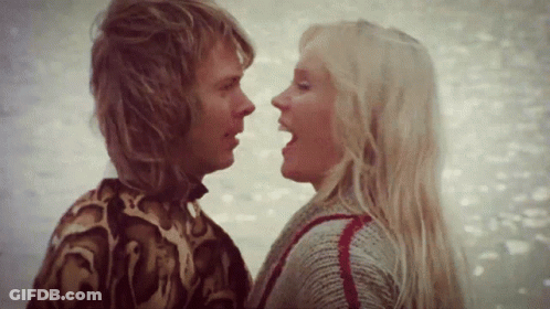 A Man And A Woman Are Looking At Each Other GIF