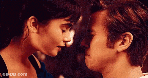 A Man And A Woman Are Looking At Each Other 'S Faces . GIF