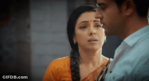 A Man And A Woman Are Looking At Each Other . The Woman Is Wearing A Braided Hairstyle . GIF