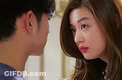 A Man And A Woman Are Looking At Each Other . The Woman Is Wearing Pink Lipstick . GIF