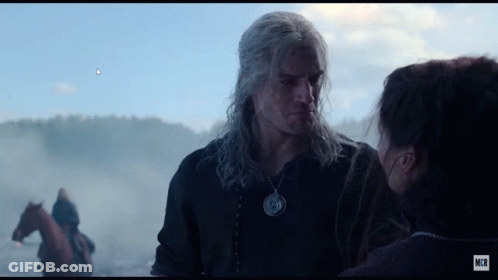A Man And A Woman Are Looking At Each Other With A Horse In The Background GIF