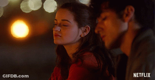 A Man And A Woman Are Looking At Each Other With A Netflix Logo In The Background GIF