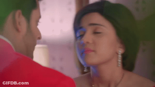 A Man And A Woman Are Looking At Each Other With Their Eyes Closed . GIF