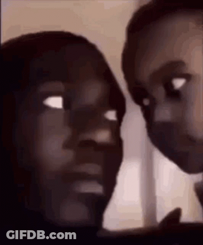 A Man And A Woman Are Looking At Each Other With Their Eyes Closed . GIF