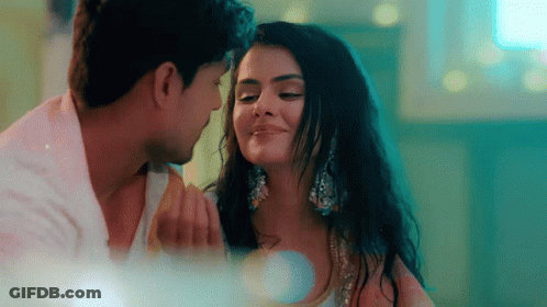 A Man And A Woman Are Looking At Each Other With Their Eyes Closed . GIF