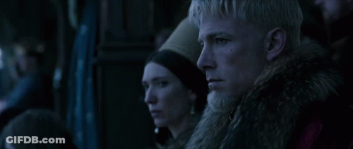 A Man And A Woman Are Looking At Something In A Dark Room GIF