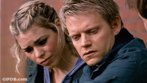 A Man And A Woman Are Looking At Something Together GIF