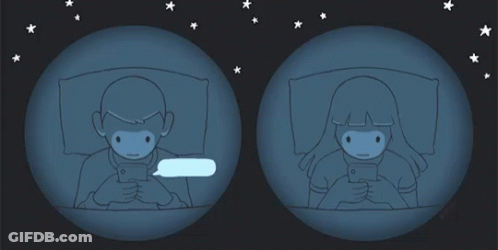 A Man And A Woman Are Looking At Their Phones GIF