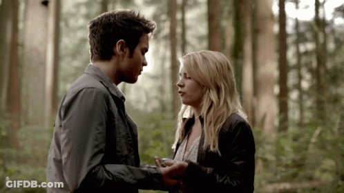 A Man And A Woman Are Looking Into Each Other 'S Eyes In A Forest GIF