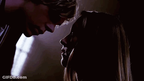 A Man And A Woman Are Looking Into Each Other 'S Eyes In The Dark . GIF