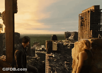 A Man And A Woman Are Looking Out Over A Ruined City GIF