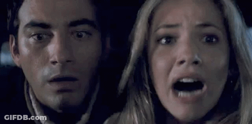 A Man And A Woman Are Looking Scared In A Car . GIF