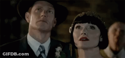 A Man And A Woman Are Looking Up At The Sky . GIF