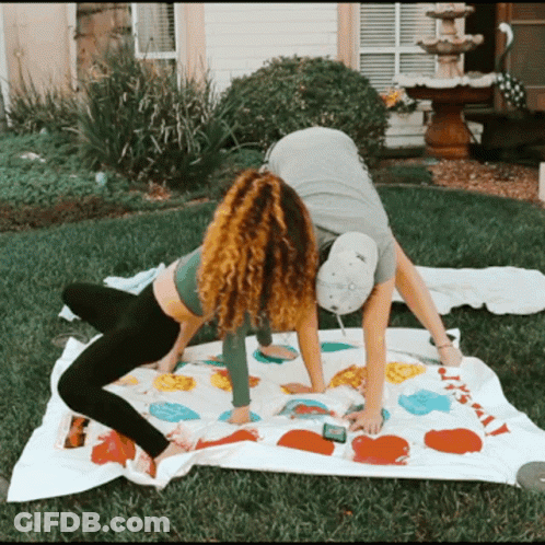 A Man And A Woman Are Playing A Game Of Twister Outside GIF