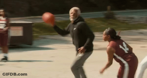 A Man And A Woman Are Playing Basketball On A Court And The Man Is Throwing The Ball To The Woman . GIF