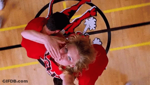 A Man And A Woman Are Playing Basketball On A Court With A Logo On The Floor . GIF
